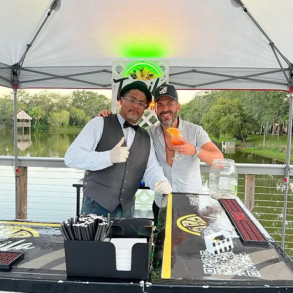 Bartender e invitado brindando bajo la carpa